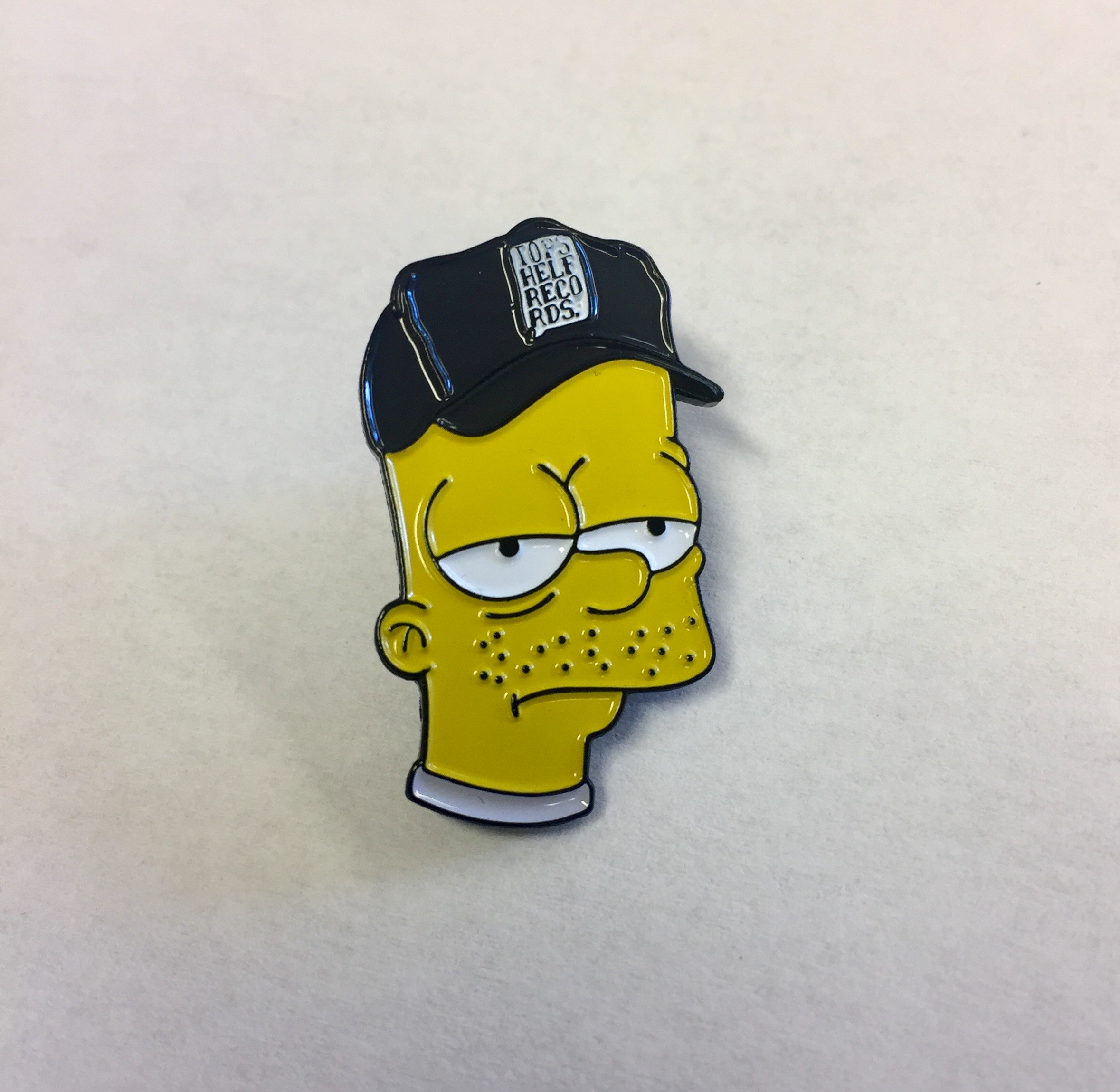 Product shots of Flower Chainz x Topshelf Records - Burn Out Bart Enamel Pin