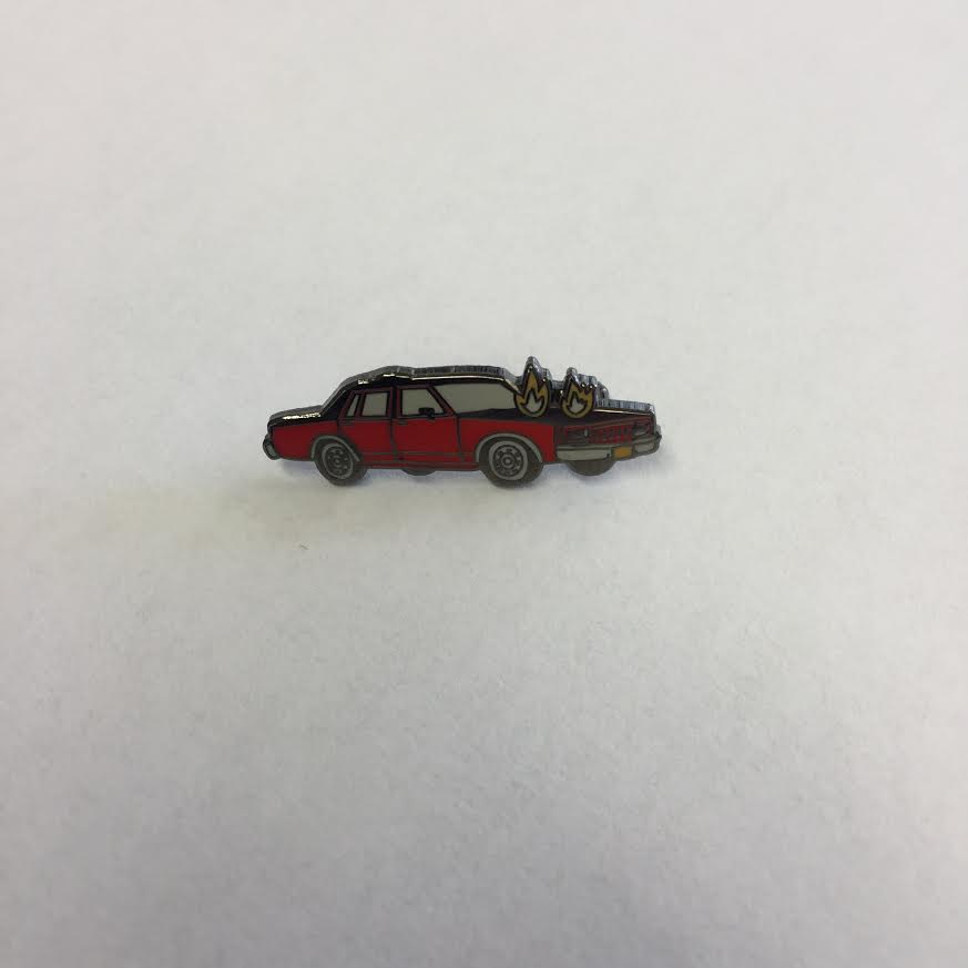 Product shots of Corey Purvis - Burning Car Enamel Pin